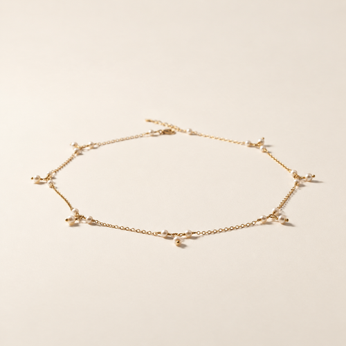 Anja Pearl Charm Necklace on warm ivory-beige background
