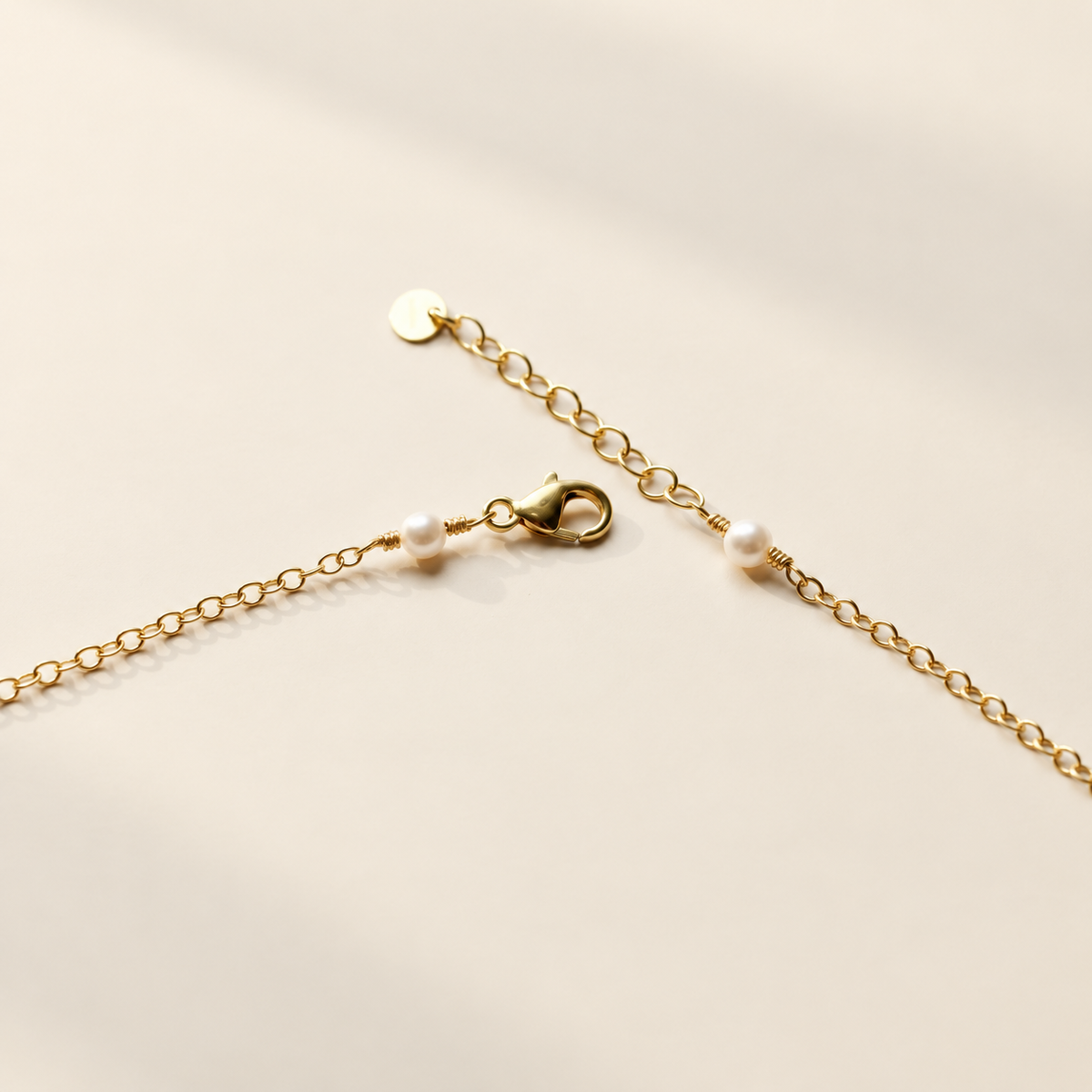 Anja Pearl Charm Necklace on warm ivory-beige background