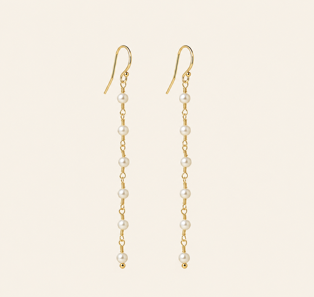 Eliane Pearl Linear Drop Earrings on warm ivory-beige background