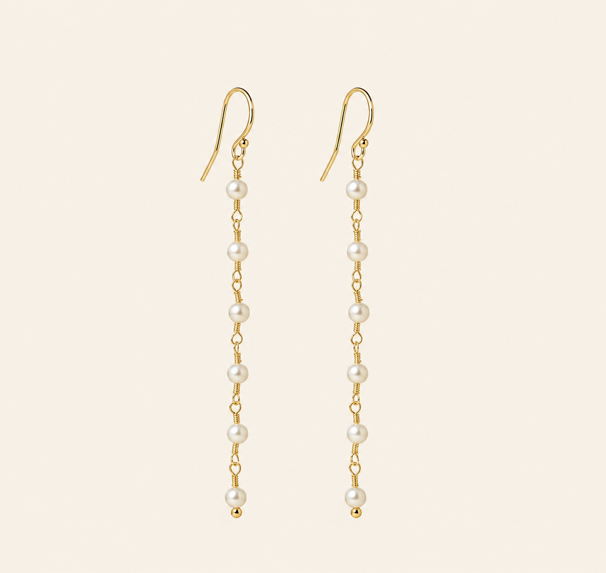 Eliane Pearl Linear Drop Earrings on warm ivory-beige background