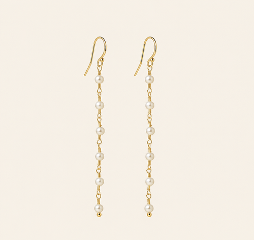 Eliane Pearl Linear Drop Earrings on warm ivory-beige background