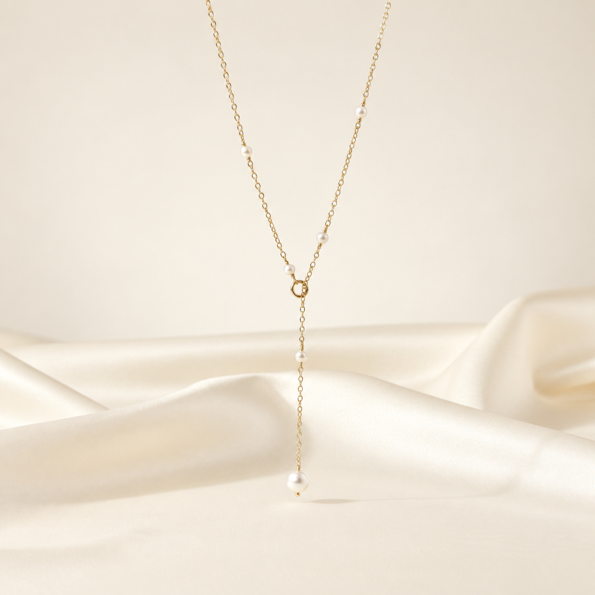Lea Dainty Pearl Necklace on warm ivory-beige background
