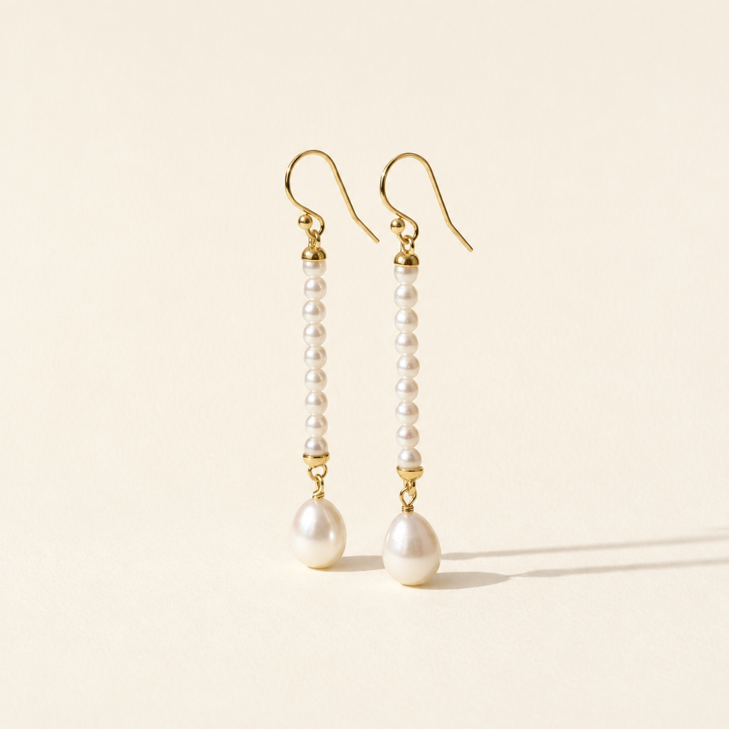 Ursina Pearl Drop Earrings on warm ivory-beige background