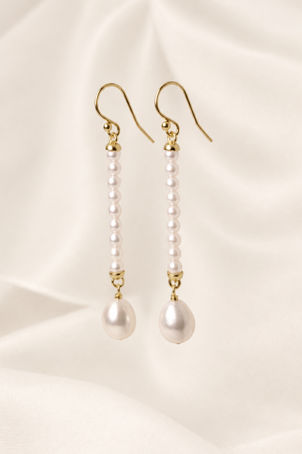 Ursina Pearl Drop Earrings on warm ivory-beige background
