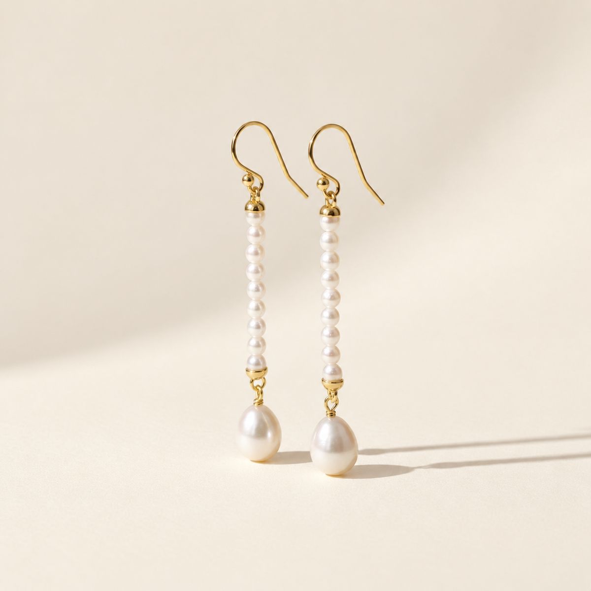 Ursina Pearl Drop Earrings on warm ivory-beige background